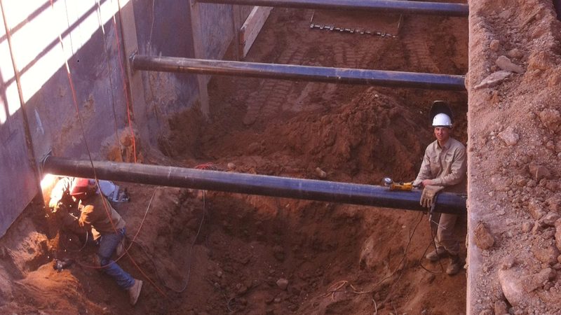 Welders in the excavation on buried process piping at a water treatment plant in Scottsdale, Arizona