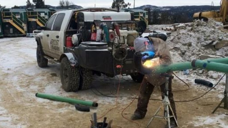 Field pipe welding on pipe stands beside a CWS welding rig