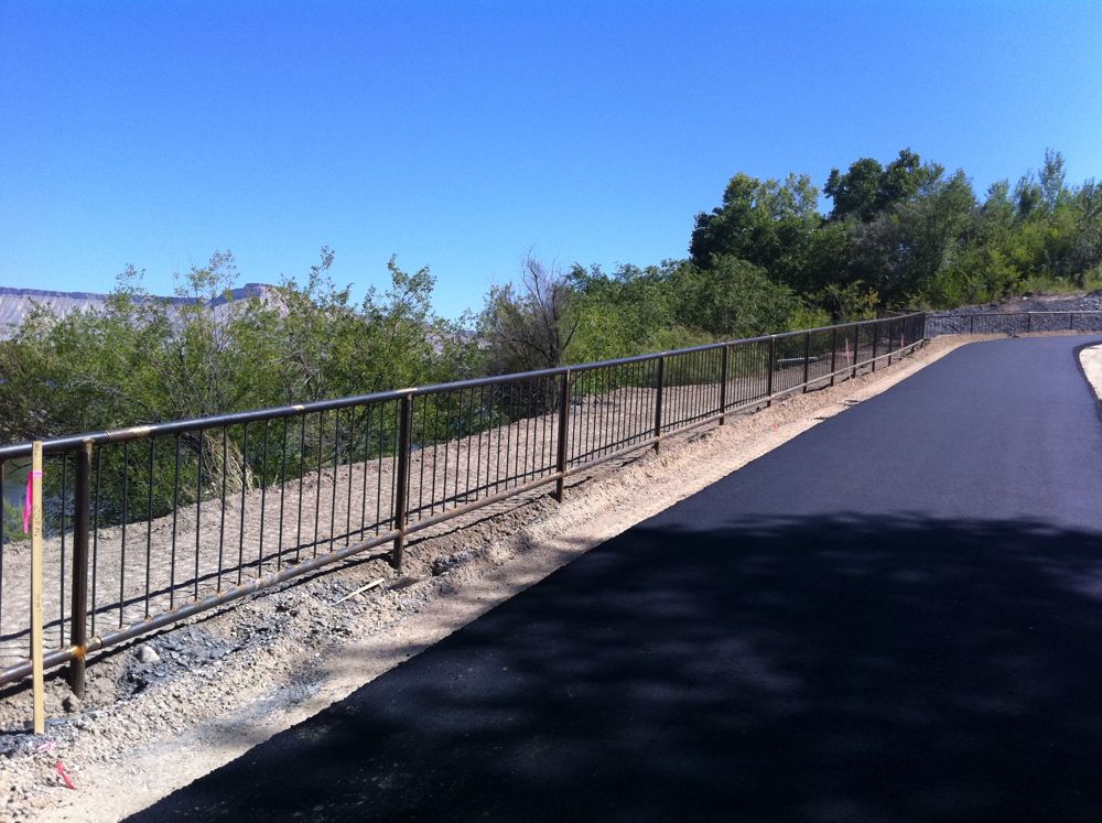 Steel handrail along a paved trail